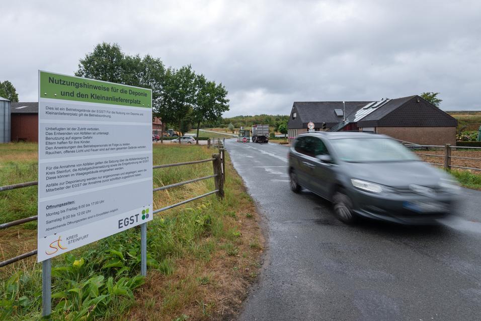 Deponie Eingangsbereich ein PKW verlässt den Eingangsbereich der Deponie. Links ein kaum lesbares Schild mit Informationen zur Deponie.