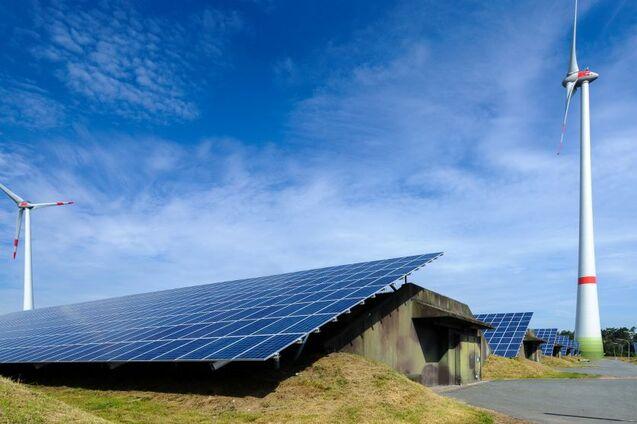 Photovoltaikanlage und Windrad vor blauem Himmel