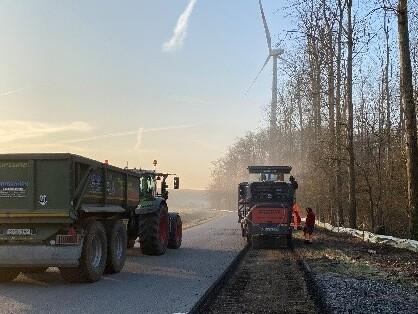 eien Straße wird mit einer Baumaschine aufgefräst.